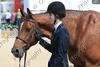 Lexus and Gabbi are waiting at the gate after successful rounds to receive the \"tricolor\" ribbon.
